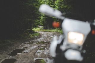 Équipement de pluie à moto Motard en veste de pluie sur une route mouillée