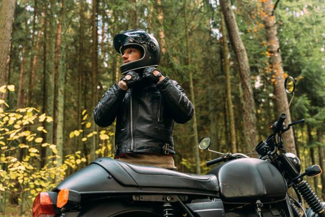 Moto à l'arrêt le long d'un trottoir, casque posé sur la selle
